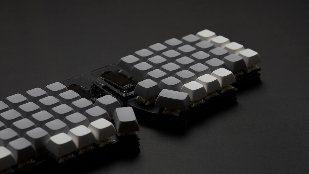 A Lily58 keyboard with alternating grey and white keycaps, photographed against a black background.