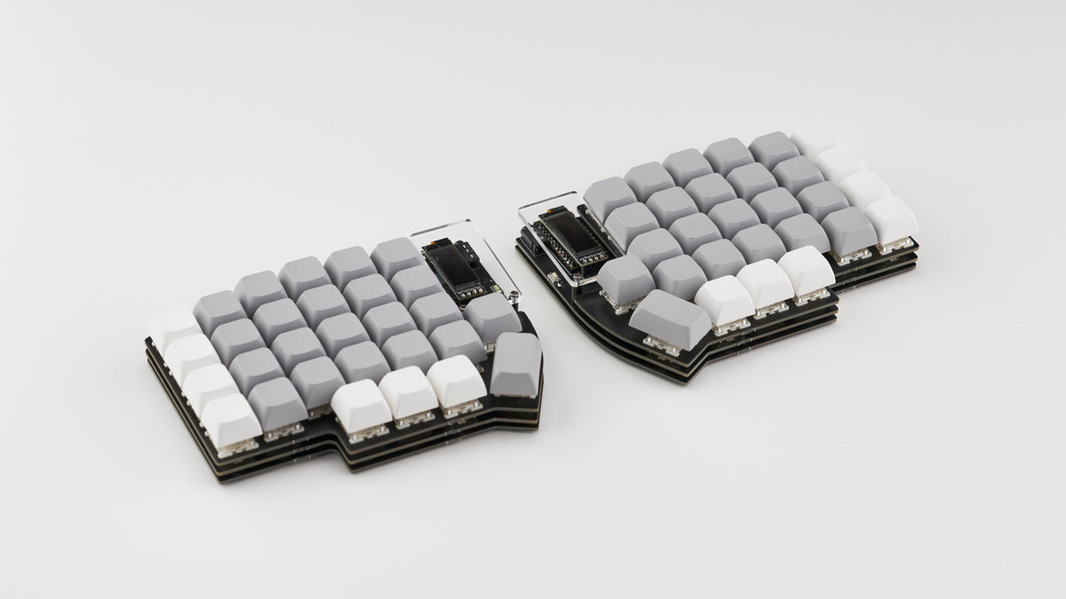 Top-down view of a split ergonomic mechanical keyboard with grey and white keycaps, shown on a clean white background. The keyboard features a minimalist design with stacked PCB layers and OLED displays on each half.
