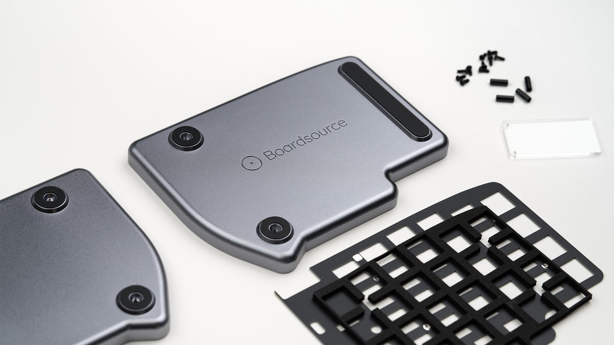 Lily Pad aluminum case halves and FR4 switch plates with included screws and standoffs, disassembled view.