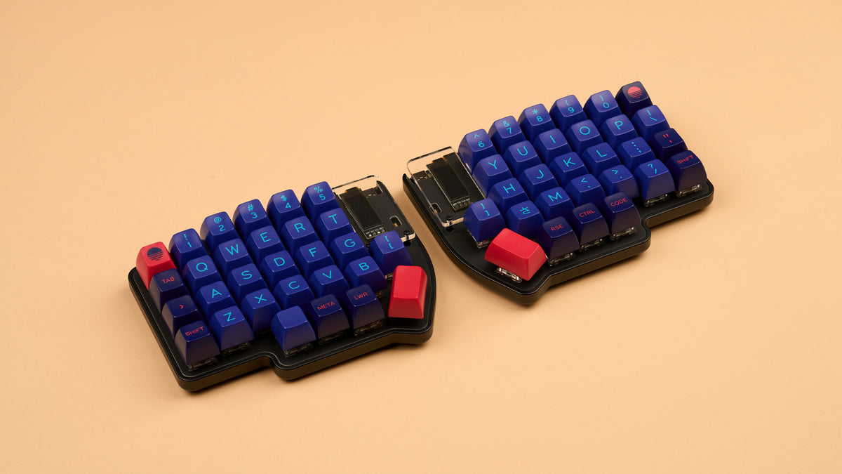 Lily Pad split 60% keyboard with black case and SA Laser keycaps on beige background