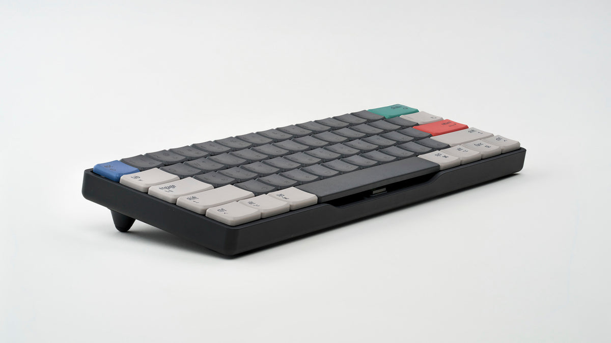 Rechteck ultra-low-profile mechanical keyboard in black aluminum with MBK Engage Dark keycaps, angled perspective using tilting legs